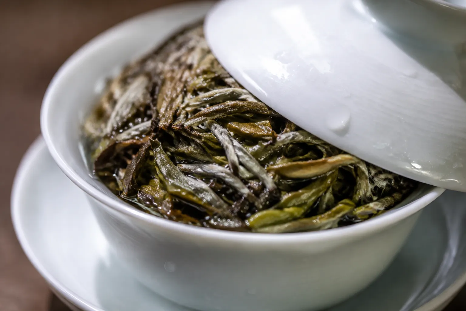 White tea leaves expanding inside a small gaiwan and narrowing the pour gap.
